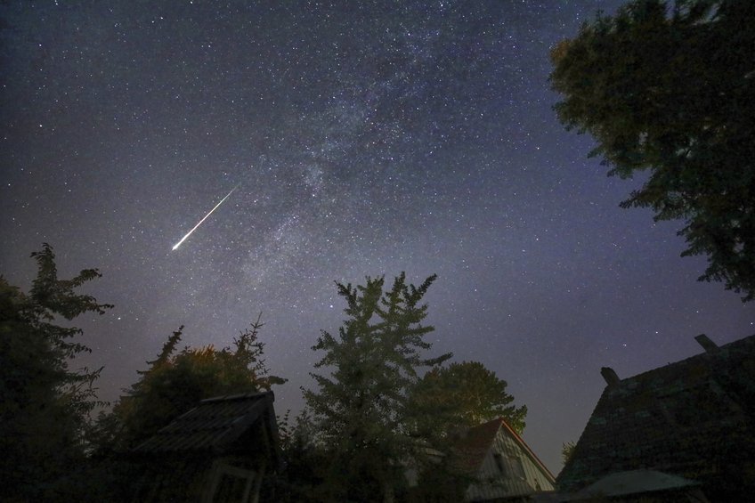 Bright Perseid meteor as seen from Neumünster (Germany) in 2023 A bright meteor streak along the Milky way which stretches between trees and rooftops across the image